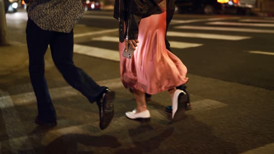 man and woman crossing the street at a crosswalk 