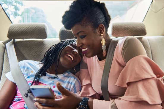 woman and girl in uber car with phone 