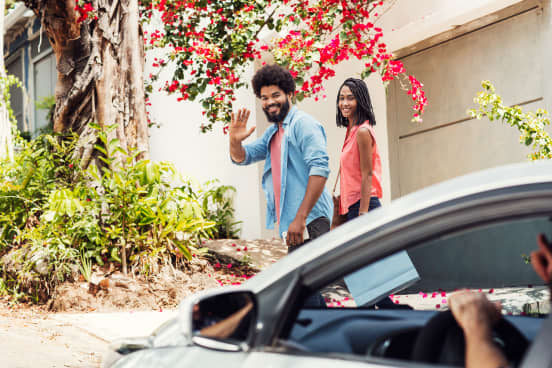 Couple waving to their Uber driver
