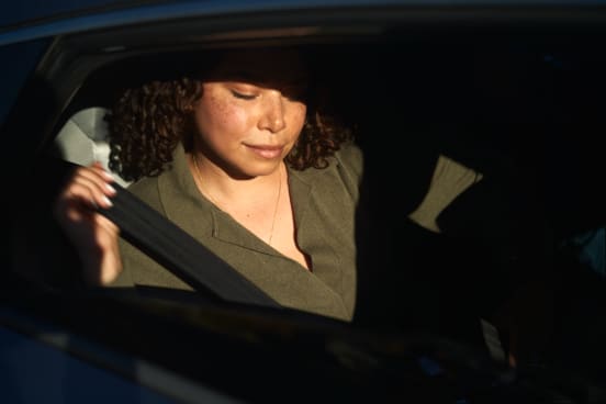 A female rider comfortably traveling in the back seat of a driver partner's vehicle.
